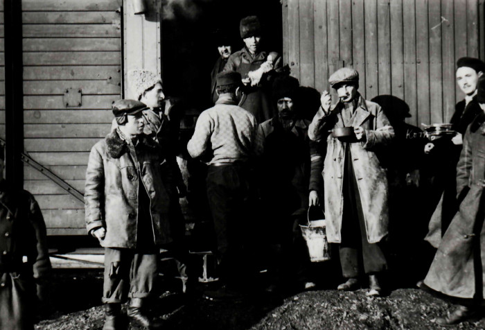 Munkaszolgálatosok egy vagon előtt esznek a miskolci vasútállomáson