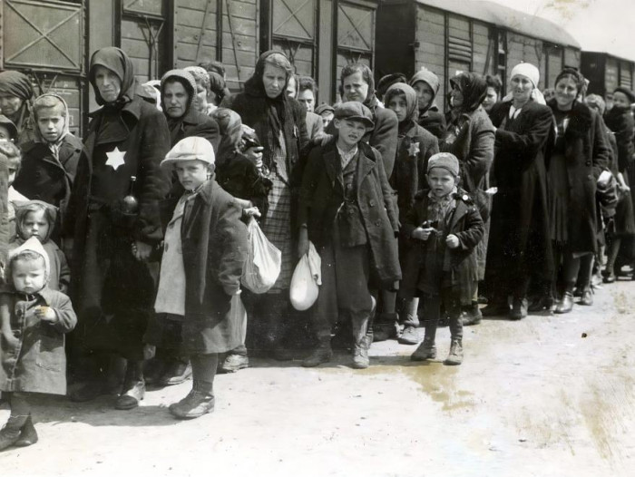 Sorban álló nők és gyerekek a vonat mellett, Auschwitz-Birkenau