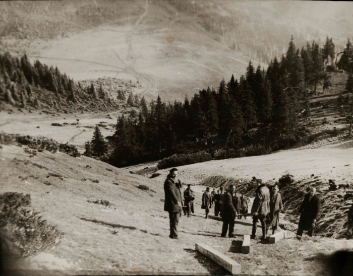 Munkaszolgálatosok gerendákat mozgatnak egy völgyben