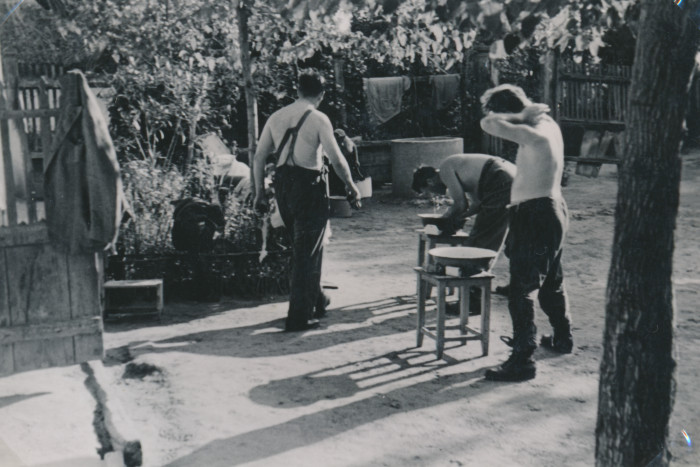 Három munkaszolgálatos mosakszik egy udvaron