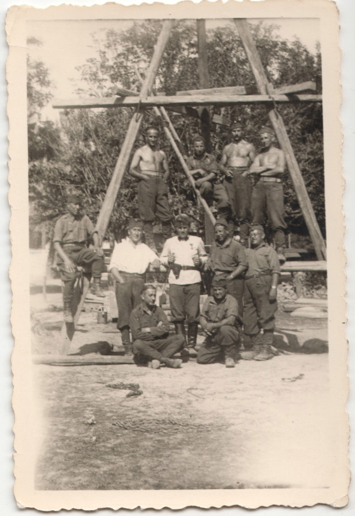 Munkaszolgálatos csoportkép egy fatákolmány előtt