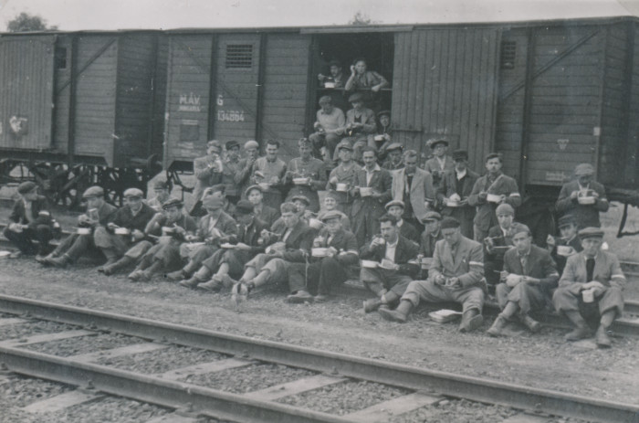 Csoportkép munkaszolgálatosokról egy vasúti kocsi előtt