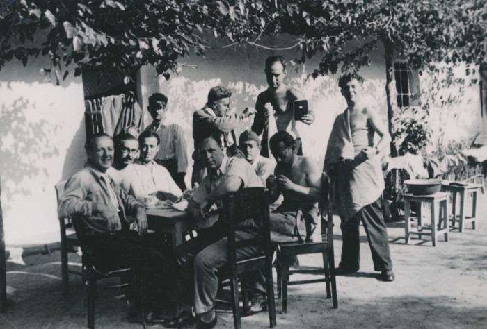 Munkaszolgálatosok csoportja egy asztal mellett egy kertben